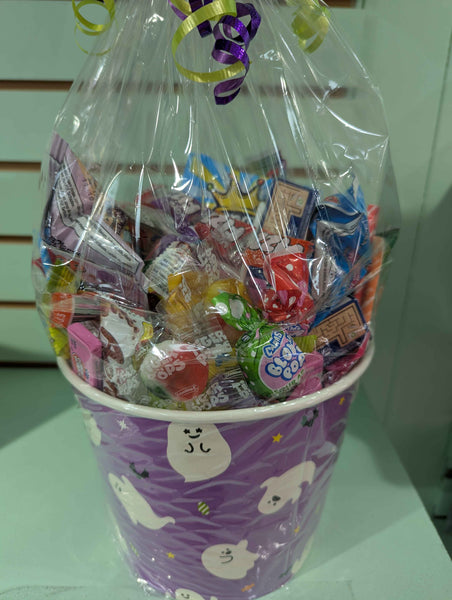 Basket filled with colorful candies and wrapped gifts, tied with ribbons.
