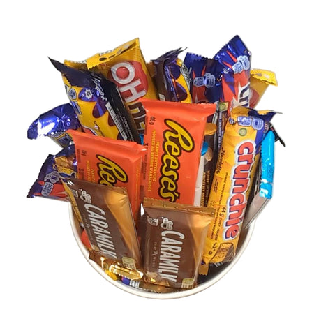 A top down view of assorted full sized chocolate bars in a halloween bucket.