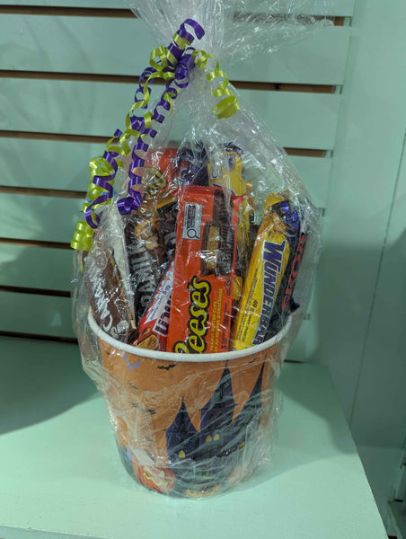 Basket filled with Halloween-themed candy bars on a white surface.