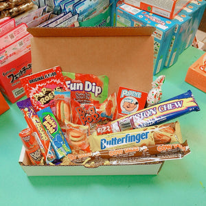 Photo of a box with a variety of chocolate bars and candies displayed open and overflowing. Charleston Chew, Butterfinger, Fun Dip, Pop Rocks, Hubba Bubba, Cow Tales and much more!